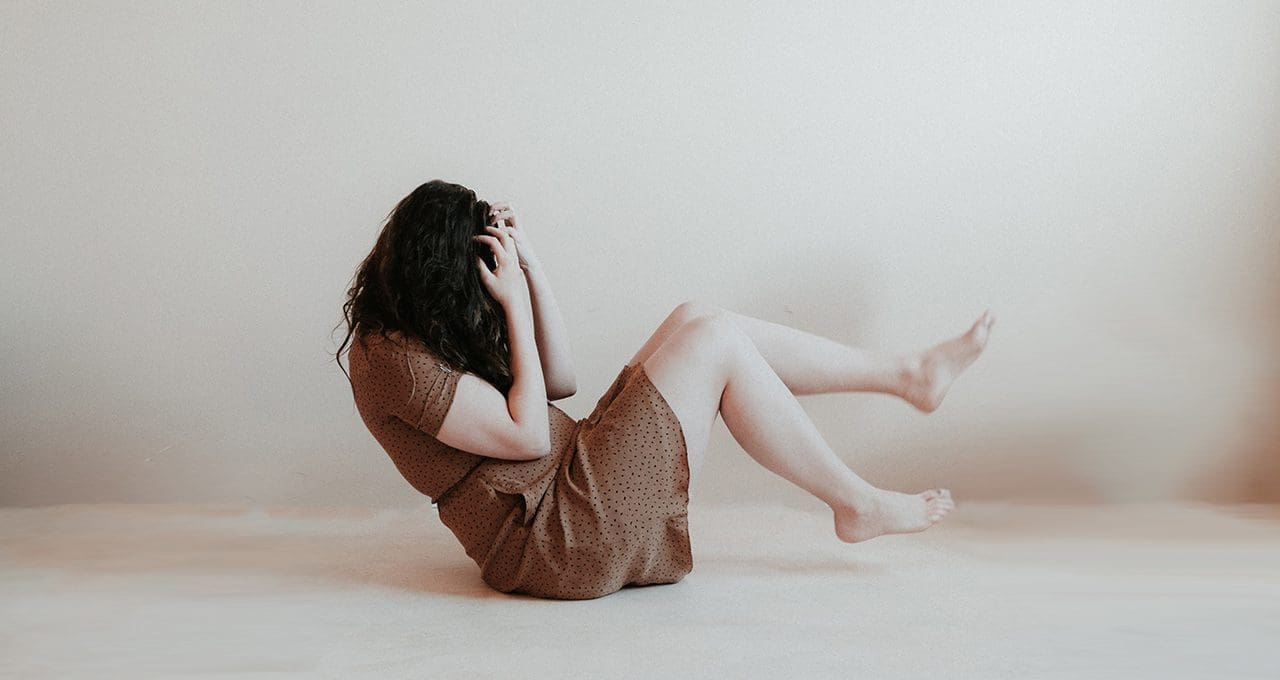 woman on ground suffering from anxiety