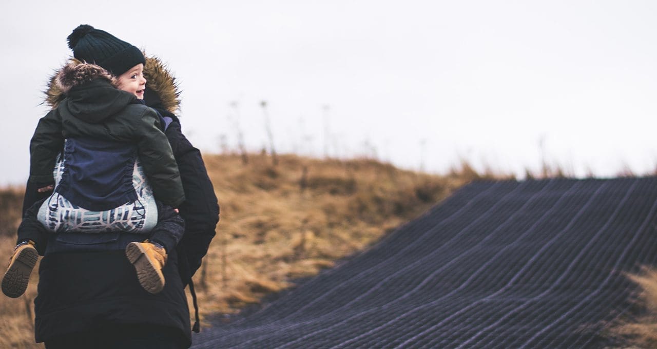 mother with child on back while hiking
