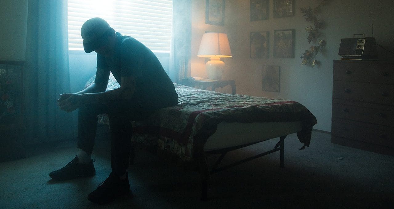 man sitting in bedroom with depression
