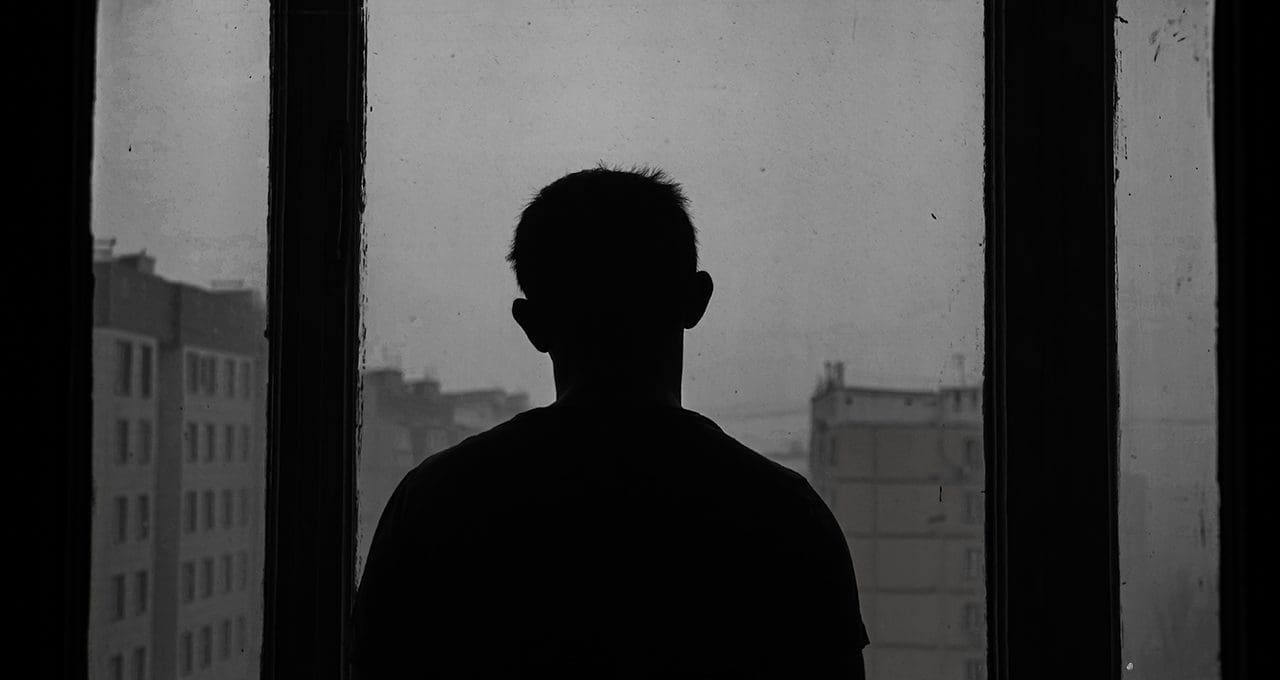 man staring out window