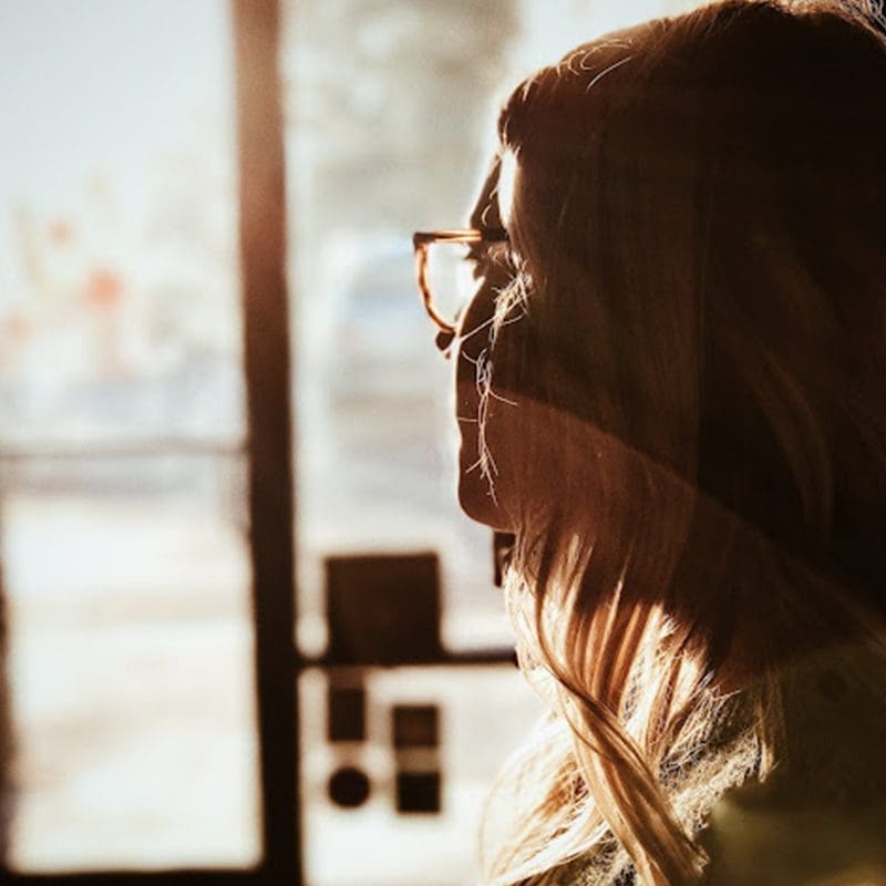woman experiencing repressed ptsd, looking out bedroom window