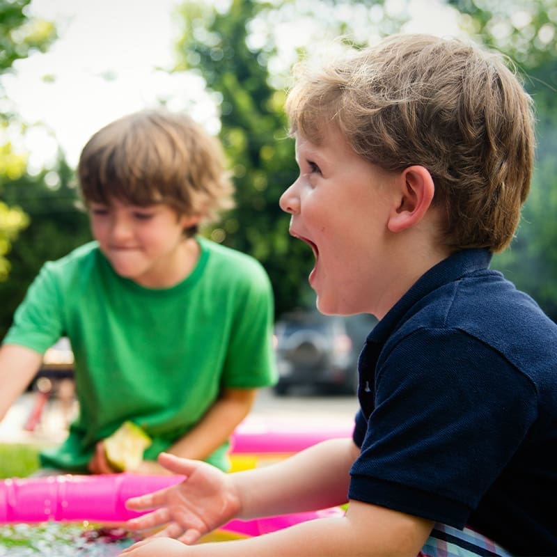 2 little kids outside 2 kids playing outside