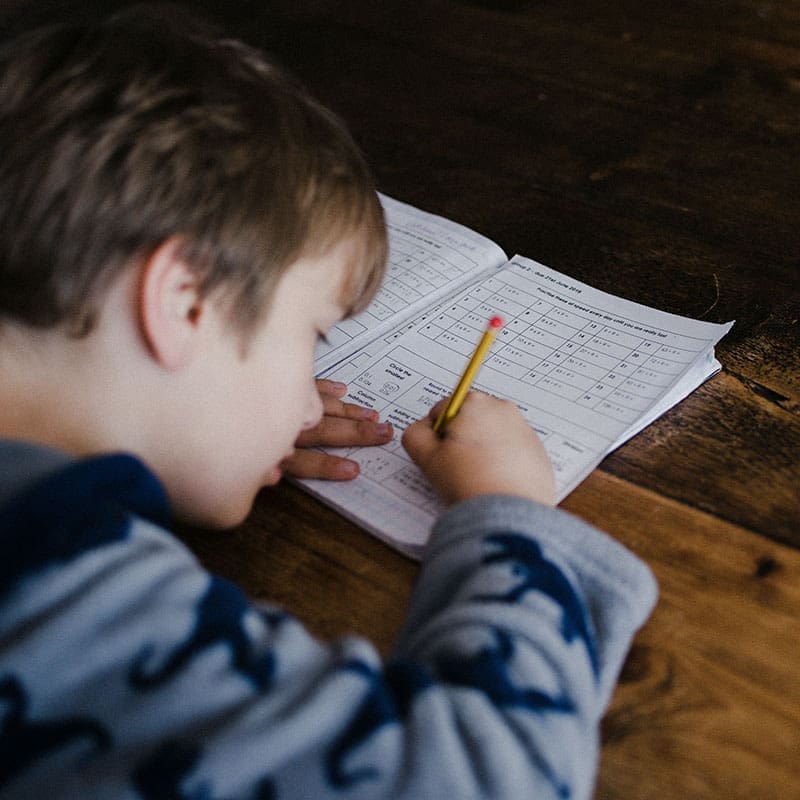 child doing homework in kitchen child doing homework