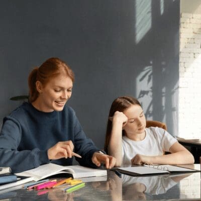happy teacher trying to teach tired girl